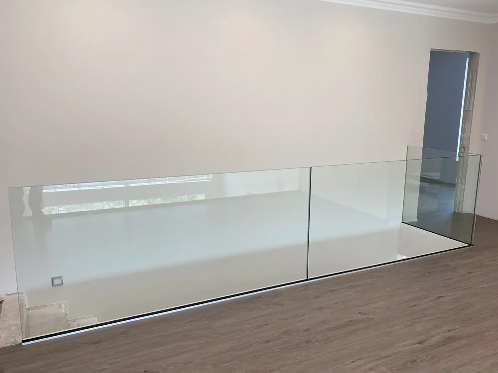 Moderne Glasbrüstung in einem Innenraum, die Sicherheit und Stil vereint, installiert von AP Glas GmbH, Delbrück.