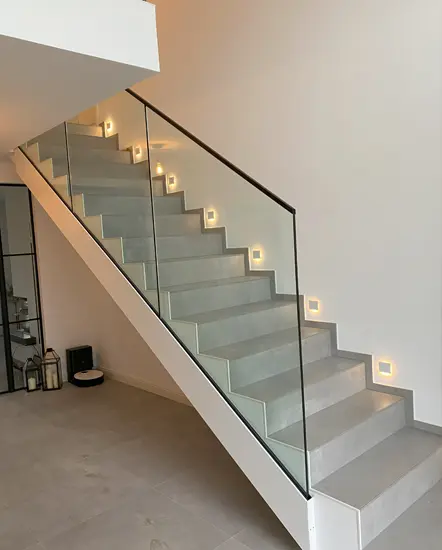 Moderne Treppe mit Glasgeländer und stimmungsvollem Licht, ideal für zeitgemäße Innenarchitektur, angeboten von AP Glas GmbH aus Delbrück.
