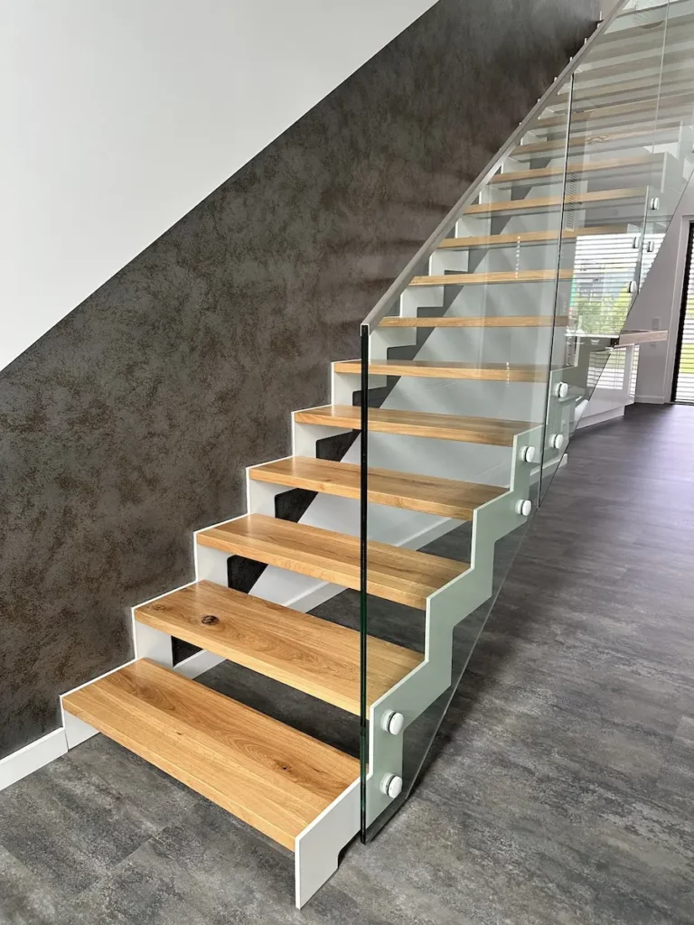 Moderne Treppe mit Holzstufen und Glasgeländer, ideal für stilvolle Innenräume, angeboten von AP Glas GmbH für bundesweite Montage von Glastreppengeländern.